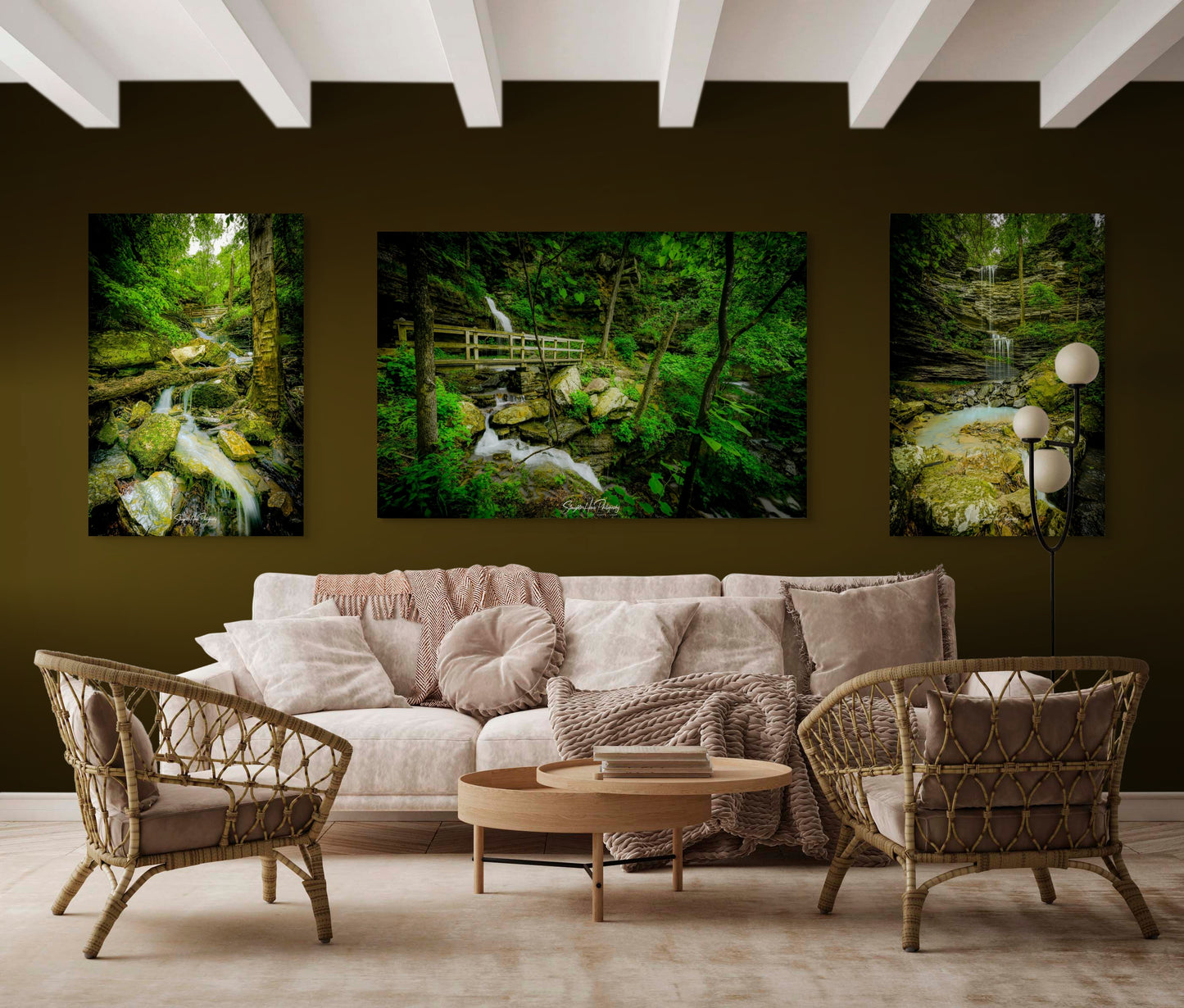 Living room with a beige sofa, wicker chairs, and a round coffee table, featuring wall art of nature scenes.